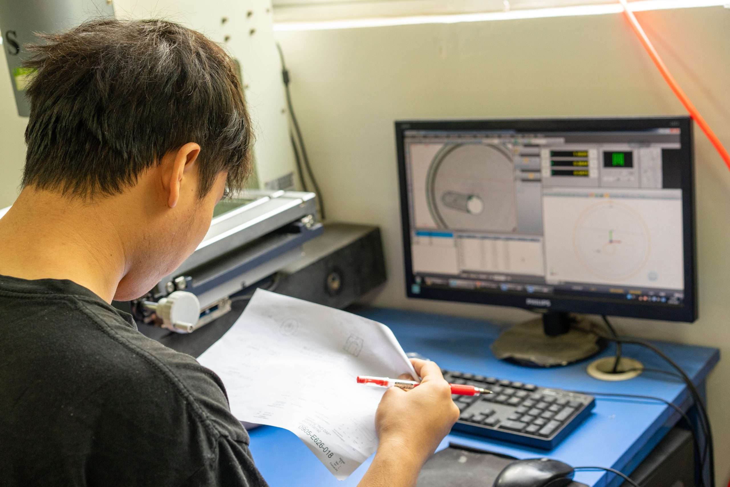 Team member reviewing a drawing at a workstation